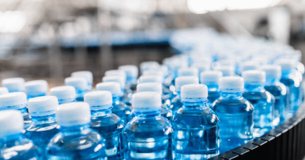 Bottles of water moving along a conveyor belt in a production facility.